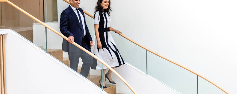 Male and Female Lazard Colleagues Walk Down Set of Stairs