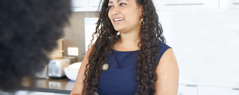 Female Lazard Colleague Smiling and Talking in Kitchen