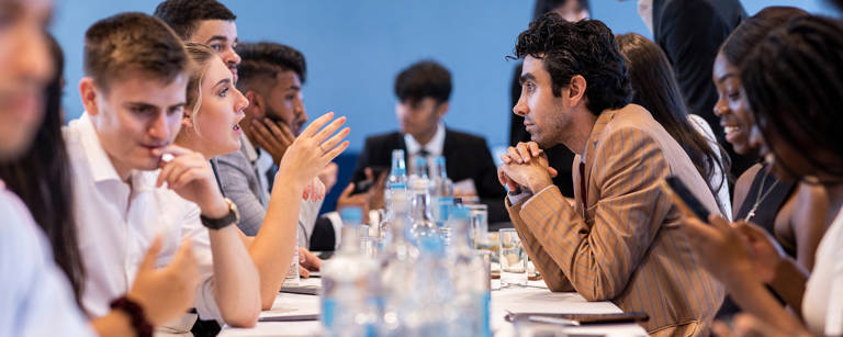 Group of Lazard Interns Talking at Long Table